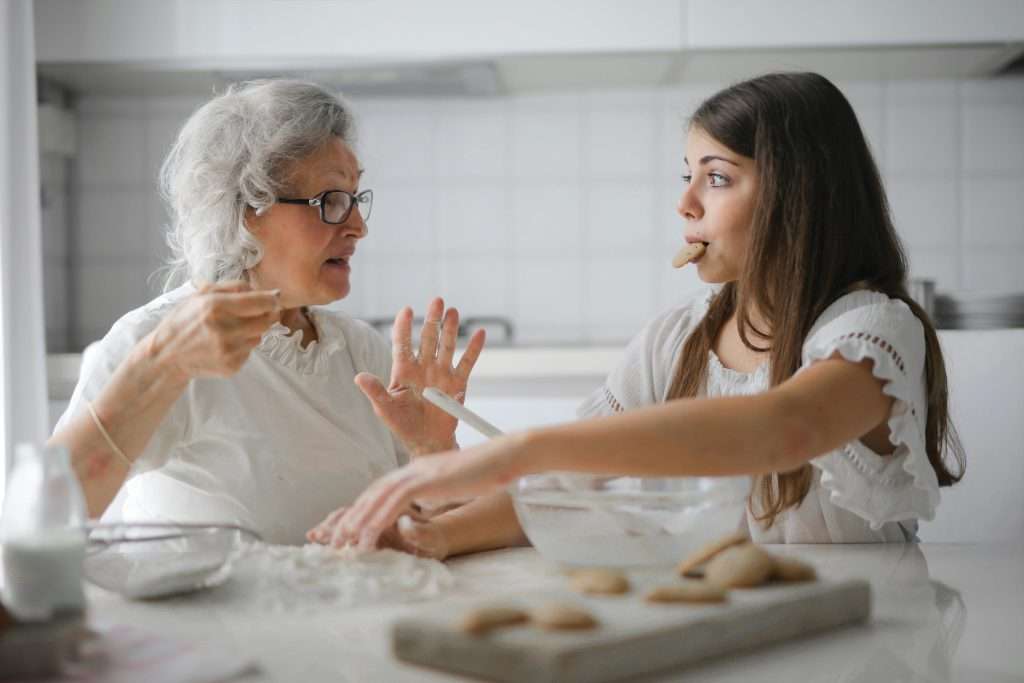 Grandma puts hand up to stop granddaughter from eating more cookies