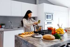 a woman enjoys cooking food in the open kitchen, cooking without a recipe