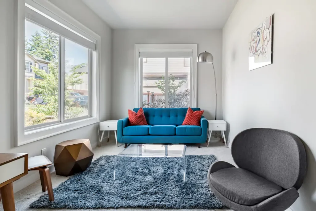 a modern sitting room with a textured rug and many sitting options invites you into contemplation and socialization
